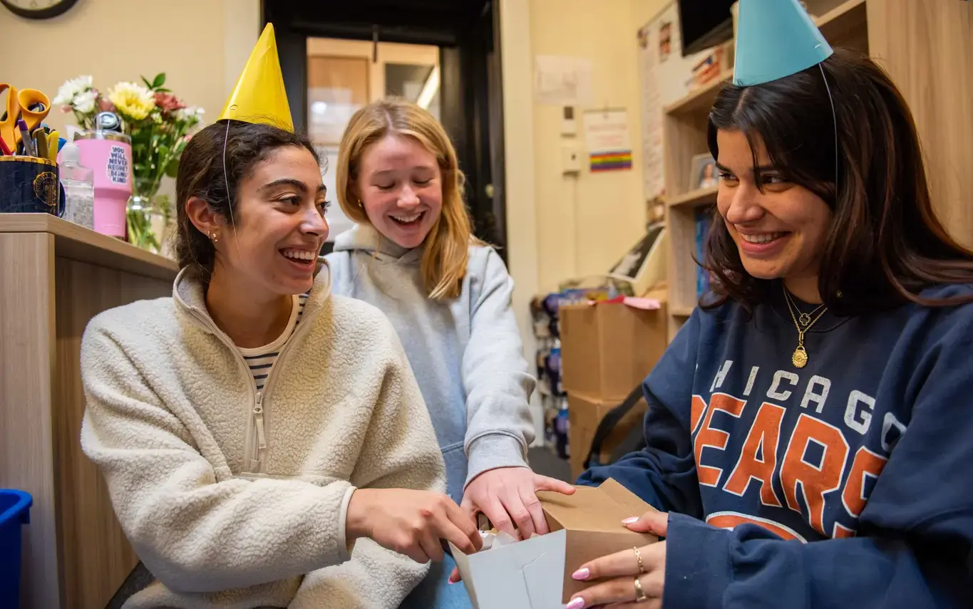 Three NCS girls wearing party hats