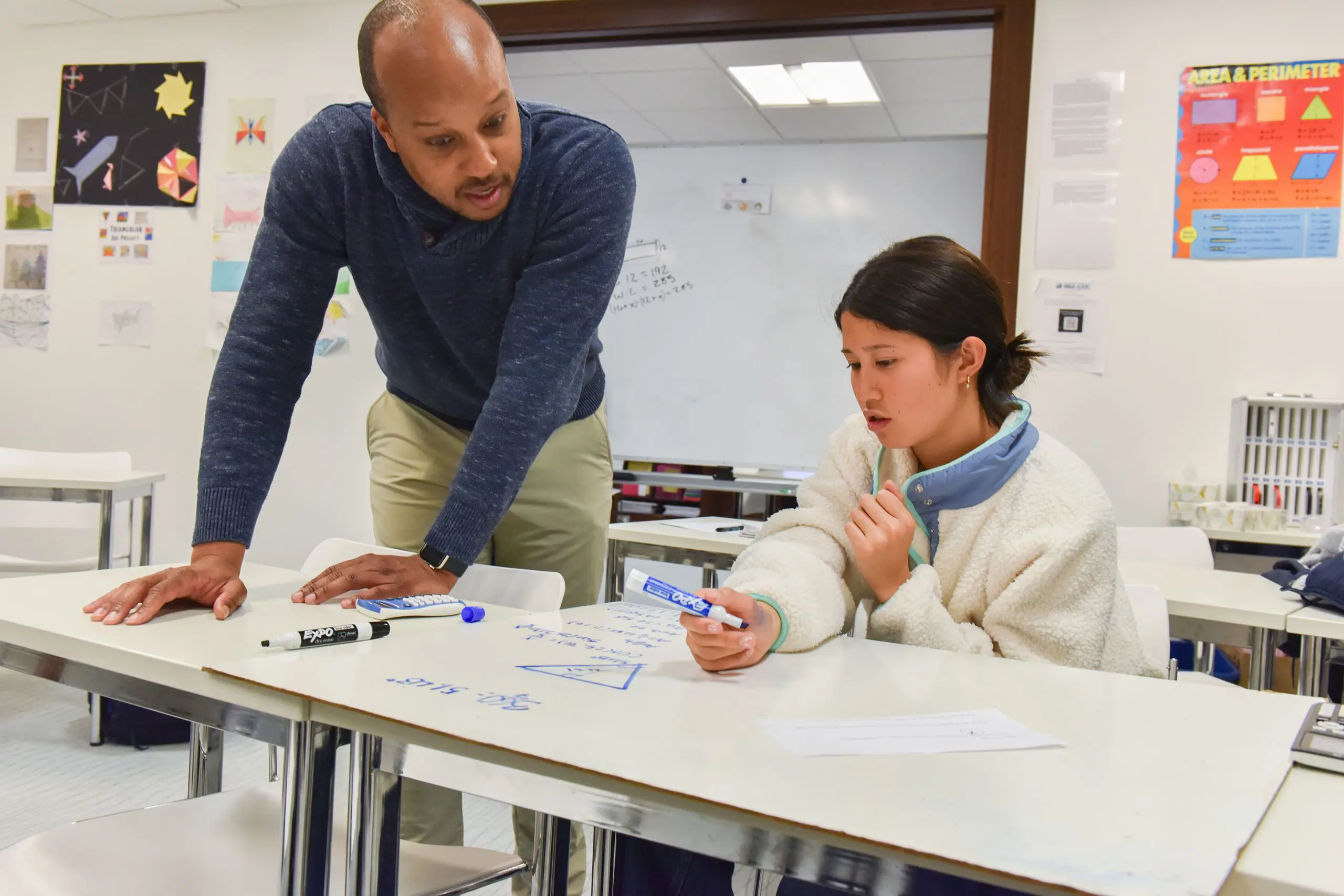 Teacher and student solving a math problem